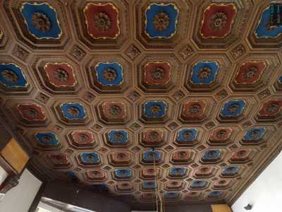 ...e, nella stanza angolare adibita a sala da biliardo, uno splendido soffitto a cassettoni con riquadri ottagonali blu e rossi, ornati da cornici dorate e rosette